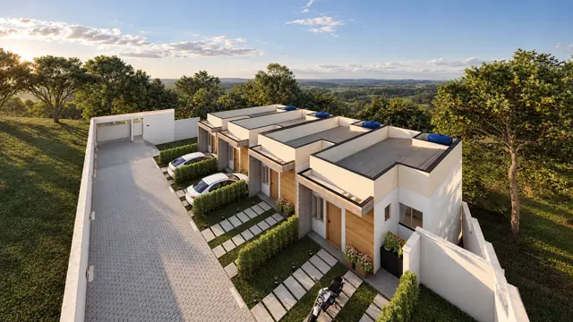 As quatro casas geminadas vistas do alto, com a rua privativa de piso intertravado, as vagas na frente e o vale ao fundo